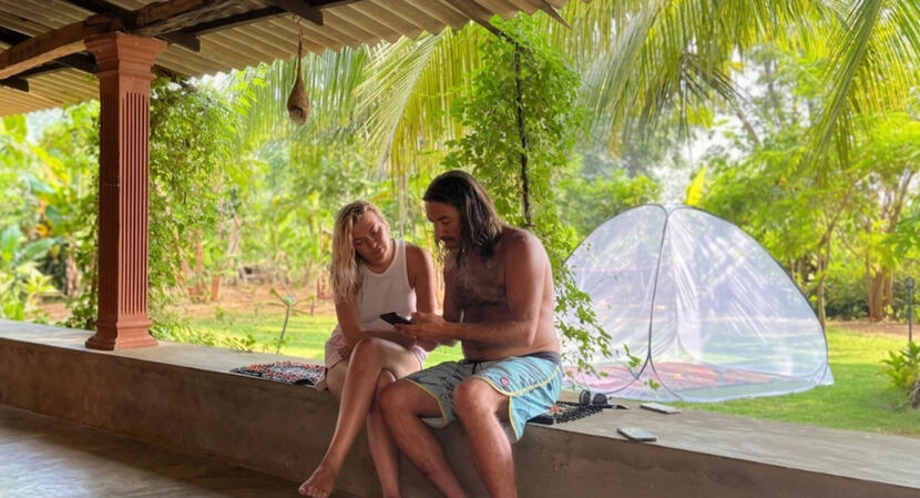 Guests relaxing and chatting with a Buddhist monk on a veranda at Rahathangama Lake Resort..